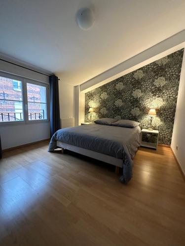 Un dormitorio con una cama y una ventana grande. en Champagne BNB - Le Duplex - Le Loft - L'Atelier - Le Cosy, en Épernay