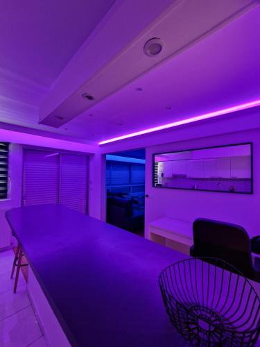 a purple room with a dining table and chairs at Superbe appartement meublé avec parking in Saint-Gratien