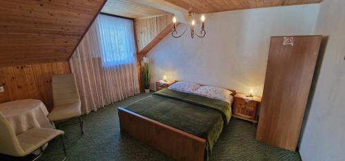 a bedroom with a bed and a chair and a window at House Samardzic in Jezerce
