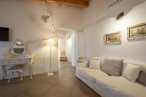 a living room with a white couch and a desk at Dimoras Dimore Esclusive in Olbia
