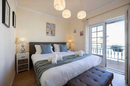 Un dormitorio con una cama grande y una ventana grande. en Vila Hortense, en Alvor