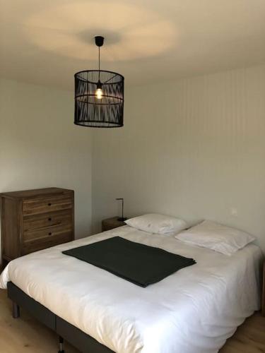 - une chambre avec un lit blanc et une lampe noire dans l'établissement Maison à Gujan-Mestras au calme, à Gujan-Mestras