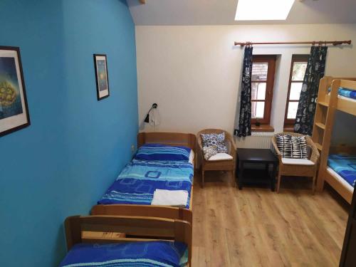 a room with three beds and a table and chairs at Ekofarma Bílý mrak in Borohrádek