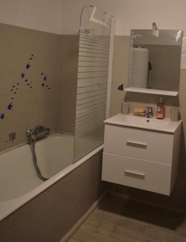 La salle de bains est pourvue d'une baignoire, d'un lavabo et d'un miroir. dans l'établissement Studio Mohange, à Morhange