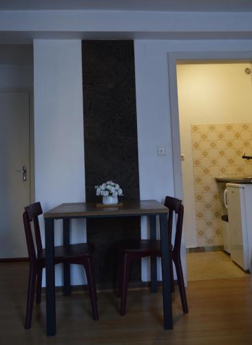 a table with two chairs and a vase of flowers on it at Studio Mohange in Morhange