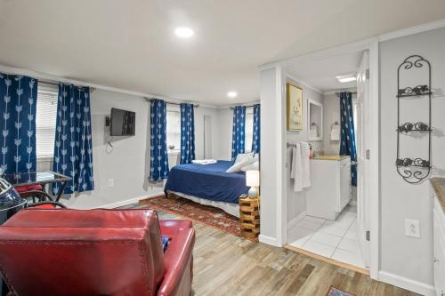 - une chambre avec un lit bleu et une chaise rouge dans l'établissement Guest House In The Heart Of Watkins Glen, à Watkins Glen