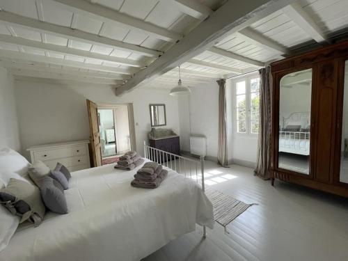 - une chambre avec un grand lit blanc et une grande fenêtre dans l'établissement Lobersane La Maison du meunier, à Saint-Laurent