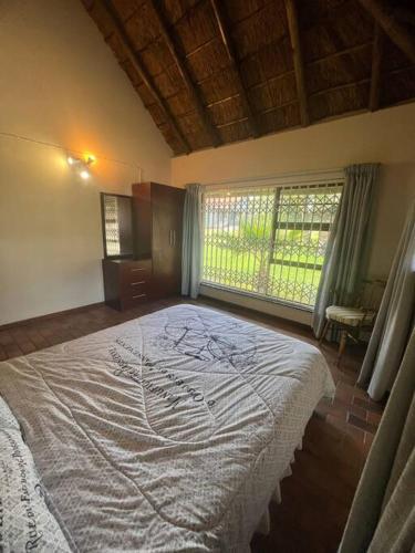 een slaapkamer met een groot bed en een raam bij Vaal Haven - riverside getaway in Vanderbijlpark