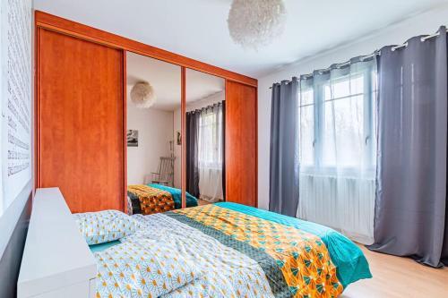 a bedroom with a bed and a window at Charmante Maison au calme in Yerres