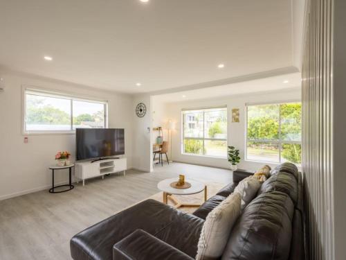 a living room with a couch and a tv at Convenient Comfort 4BR near Malls and Transport in Brisbane
