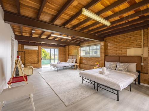 a large room with two beds and a couch at Convenient Comfort 4BR near Malls and Transport in Brisbane