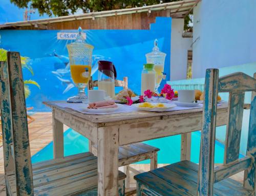 a table with a plate of food and drinks on it at Casarão Jeri in Jericoacoara