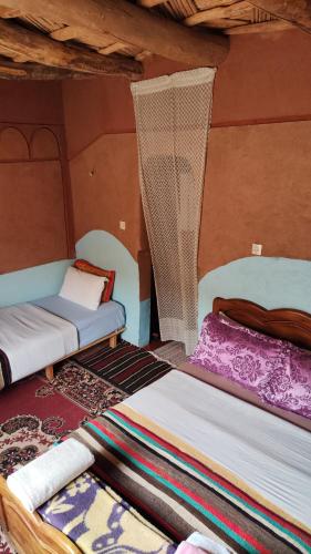two beds sitting in a room with at maison isabel in Boumalne