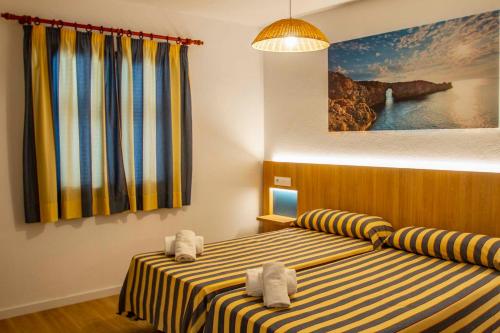 ein Schlafzimmer mit 2 Betten und Handtüchern darauf in der Unterkunft Apartamentos Sol y Mar II in Cala en Blanes