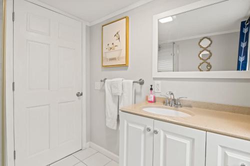 een witte badkamer met een wastafel en een spiegel bij Guest House In The Heart Of Watkins Glen in Watkins Glen