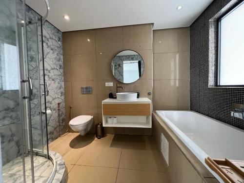 a bathroom with a tub and a sink and a toilet at Bel Appartement en face de la mer in Dakar