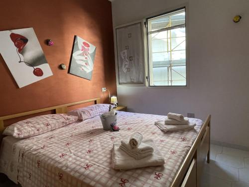 1 dormitorio con 1 cama con toallas en Maison A La Plage, en Baia Verde