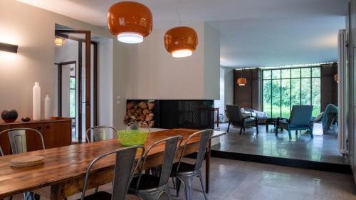 a dining room with a wooden table and chairs at Le Moulin des Rives - Somptueuse demeure du XIIème in Romagne