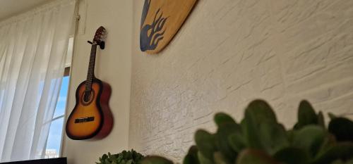 a guitar hanging on a wall next to a cactus at Attico Mexico in Pescara