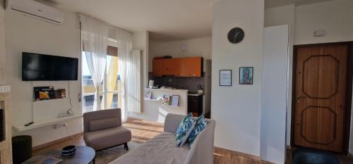 a living room with a couch and a table and a kitchen at Attico Mexico in Pescara