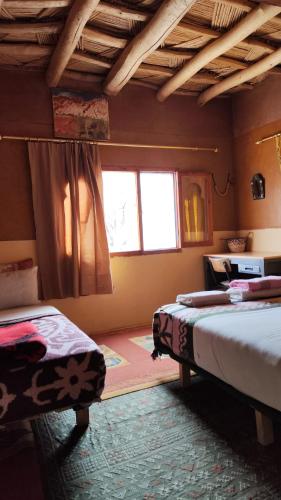 a bedroom with two beds and a window at maison isabel in Boumalne