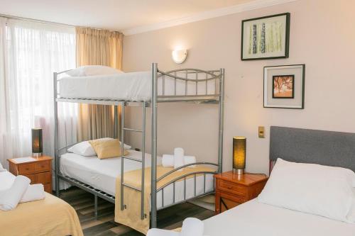 um pequeno quarto com 2 beliches e 2 camas em Hotel Murano em Concepción