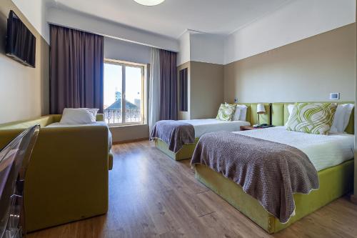 a hotel room with two beds and a window at Hotel Porto Mar in Matosinhos