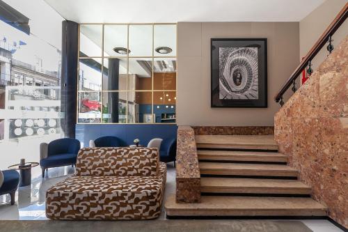 a lobby with a staircase with a couch and chairs at Hotel Porto Mar in Matosinhos