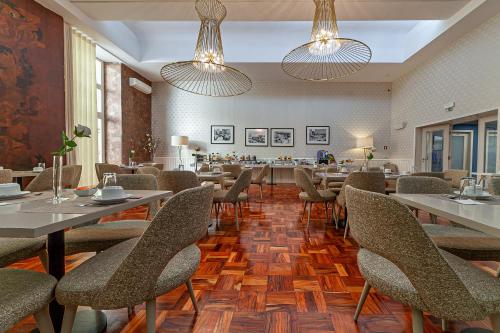 a dining room with tables and chairs and lights at Hotel Porto Mar in Matosinhos