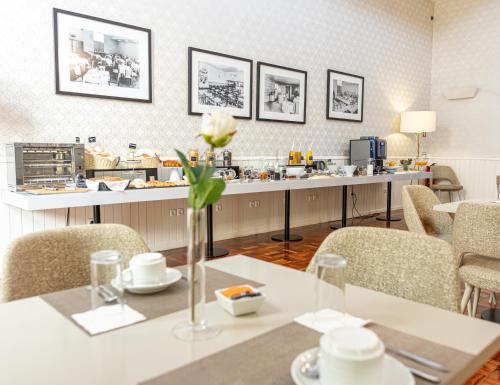a restaurant with a table with a flower in a vase at Hotel Porto Mar in Matosinhos