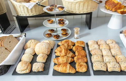 a table with various types of bread and pastries at Hotel Porto Mar in Matosinhos