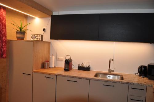 a kitchen with a sink and a counter top at Hotel Maroi in Wald am Arlberg