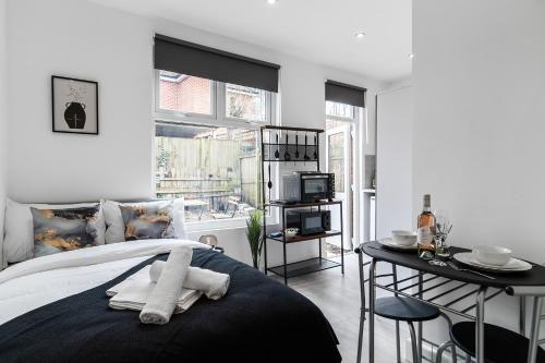 um quarto com uma cama, uma mesa e uma televisão em Modern Studio Rooms in Zone 2 London em Londres