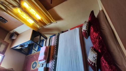 a room with a window with a curtain and a curtain at maison isabel in Boumalne