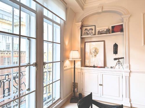 a room with a large window and a lamp at Spacious and beautiful flat in Mayfair, Berkeley St in London