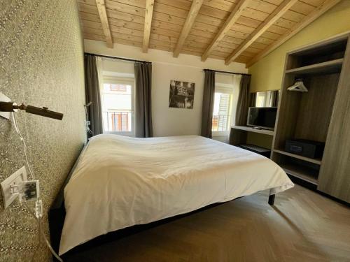 een slaapkamer met een groot wit bed in een kamer bij Saragozza Suite 7 Attico con altana a due passi da Piazza Grande WIFI e parcheggio gratuito in Modena