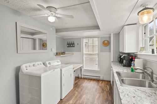 a kitchen with white appliances and a sink at Home In The Heart Of Watkins Glen With Hot Tub And Game Rm in Watkins Glen
