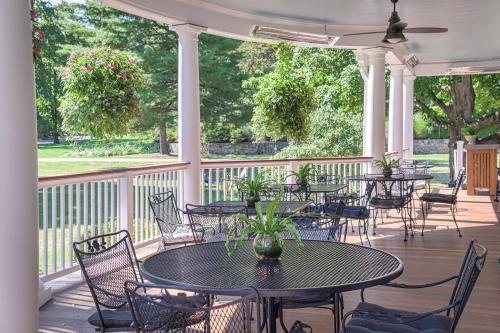 a patio with tables and chairs on a porch at The West Lane Inn in Ridgefield