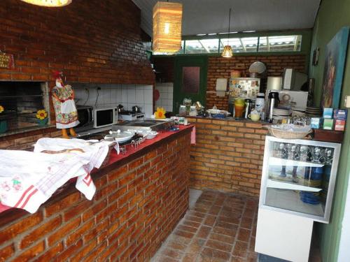 uma cozinha com um balcão de tijolos e uma parede de tijolos em Pousada Girassois Hostel em Florianópolis