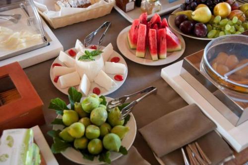 a table topped with plates of food with fruit at La Dimora di Spartivento - BW Signature Collection in Ragusa