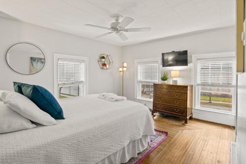 a white bedroom with a bed and a ceiling fan at Home In The Heart Of Watkins Glen With Hot Tub And Game Rm in Watkins Glen