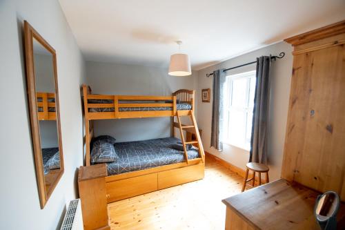 a bedroom with two bunk beds and a mirror at 3 Fishery Cottages - 2 Bedroom house close to town in Bundoran