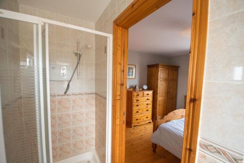 a bedroom with a walk in shower and a bed at 3 Fishery Cottages - 2 Bedroom house close to town in Bundoran