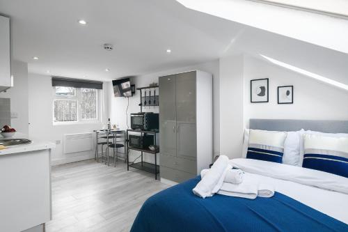 a bedroom with a blue and white bed and a kitchen at Modern Studio Rooms in Zone 2 London in London
