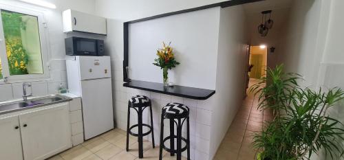 a kitchen with two stools next to a counter at Le Madina in Pamandzi