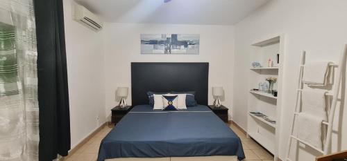 Pamandzi的住宿－Le Madina，一间白色客房内的蓝色床卧室