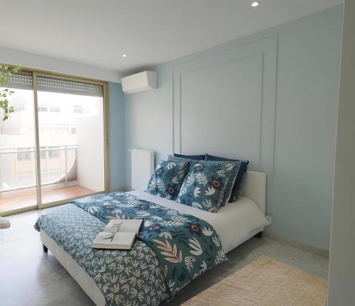 - une chambre avec un lit et un livre dans l'établissement Le REGENCY, appartement familial au cœur du centre-ville, des célèbres jardins Biovès, et seulement à 1 minute à pied de la plage, à Menton