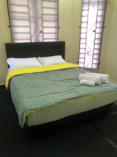 1 dormitorio con 1 cama con 2 toallas en A & Z Roomstay, en Pasir Mas