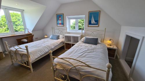 Habitación con 2 camas individuales y 2 ventanas. en Tantallon, en Saint Just in Roseland