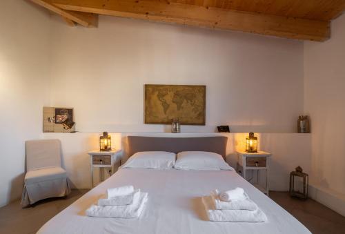a bedroom with a white bed with towels on it at Dimoras Dimore Esclusive in Olbia